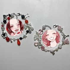 two necklaces with pictures of women on them, one is red and the other is white