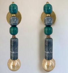 two wall sconces with marble and brass accents on each side, one has a light bulb in the middle