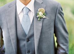 a man in a suit and tie with a boutonniere on his lapel