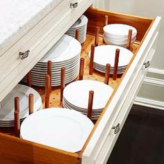 an open drawer in a kitchen filled with plates