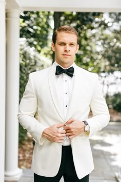 a man in a white tuxedo and black bow tie