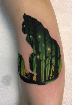 a person with a tattoo on their arm that has a bear in the woods at night