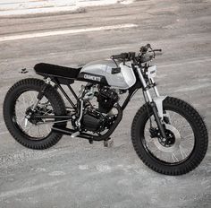 a white and black motorcycle parked on top of a parking lot