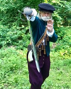 an old man dressed in period clothing and holding a fan