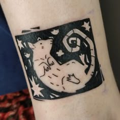 a tattoo on the arm of a person with a cat and stars around her neck