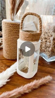 a white lantern sitting on top of a wooden table next to two baskets filled with feathers