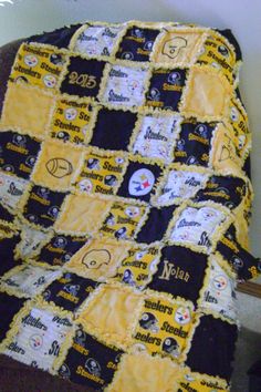 a blanket that is sitting on top of a chair in front of a wall with the pittsburgh football team's name written on it