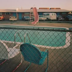 an empty swimming pool with chairs and a slide next to it in a motel or motel