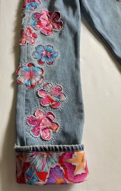 an old pair of jeans with embroidered flowers on them