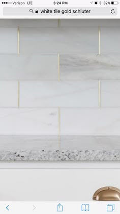 a white marble tile backsplash with gold accents