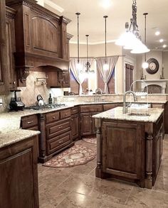 a large kitchen with marble counter tops and wooden cabinets