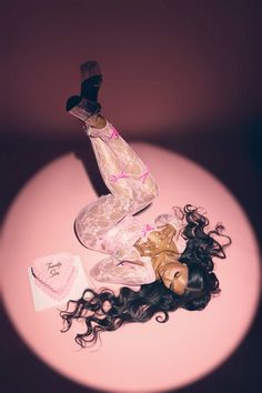 a woman laying on top of a table next to a hair dryer and an envelope