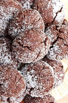 powdered sugar cookies are piled on top of each other in a bowl, ready to be eaten