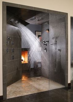 a shower head with water coming out of it and a fire place in the background