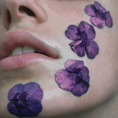 a woman with purple flowers painted on her face