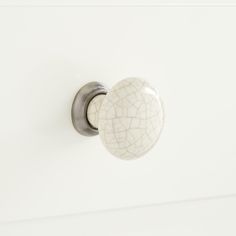 a white cabinet door with a cracked knob