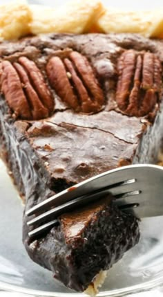 a piece of chocolate pie on a plate with a knife and fork in the middle