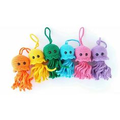 crochet octopus keychains are lined up on a white surface with eyes drawn on them