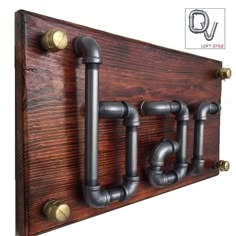 a wooden coat rack with metal pipes and knobs on the front, along with two brass - plated handles