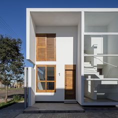 a white house with wooden shutters on the front and stairs to the second floor