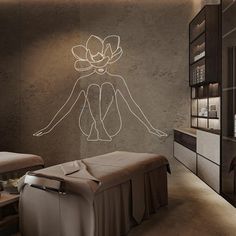 a spa room with a large drawing on the wall next to a foot massage table