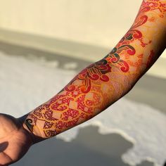 a person's arm covered in red and orange tattoos