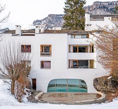 a white building with lots of windows and snow on the ground