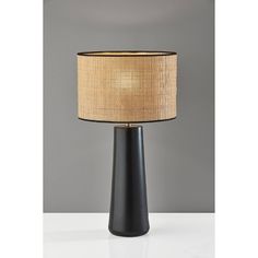 a black table lamp with a beige shade