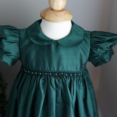 This Strasburg Emerald Green Dress Size 24 Months Is Most Gorgeous!!! Made Of 100% Luxurious Dupioni Silk. Smocking At Waist With Hand Embroidery Emerald Rosettes With White Pearls In Between. Sweet Peter Pan Collar That Is Edged In Matching Piping. Waist Is Trimmed In Matching Piping Also. Short Puff Sleeves Are Finished With A 1 Inch Matching Silk Band.Upper Button Back With Matching Silk Fabric Buttons (High-End Detail). A Wide Tie Back Sash Is The Finishing Touch With This Exquisite Strasbur Emerald Green Dress, Emerald Green Dresses, Cotton Slip, Dupioni Silk, Fabric Buttons, Green Pearls, Dress Silk, Studio Portraits, Pan Collar