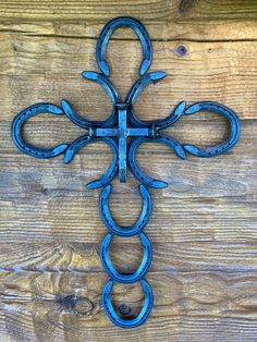 an iron cross is hanging on the side of a wooden wall