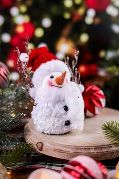 a white snowman sitting on top of a wooden table