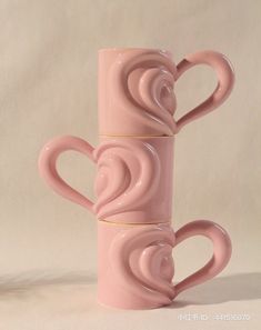 two pink coffee mugs sitting next to each other on a white surface with the words love written in it