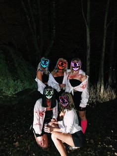 a group of people wearing masks in the dark