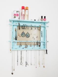 a blue shelf with jewelry hanging from it's sides