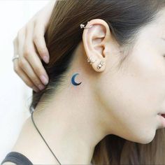 a woman wearing ear piercings with the moon on her left side behind her ear