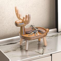 a wooden toy sitting on top of a counter with keys in it's mouth