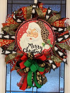 a christmas wreath hanging on the front door with santa clause's head and words merry christmas