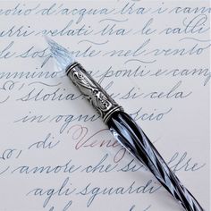 a fountain pen sitting on top of an old handwritten paper