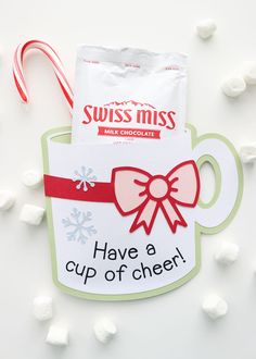 a cup of cheer ornament with candy canes around it