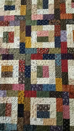 a quilt made with different colored squares on it's sides and the bottom half