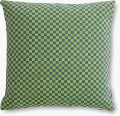 a green and yellow checkered pillow on a white background