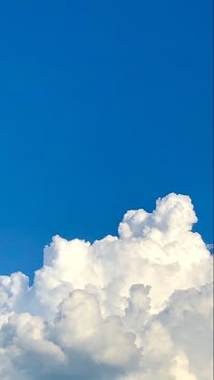 an airplane flying high in the sky with clouds behind it and a jet plane above