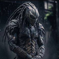 the predator character is standing in the rain