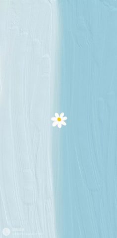 a single white flower sitting on top of a blue and white wall next to the ocean