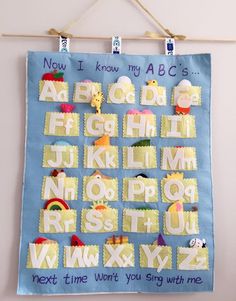 a child's hand made alphabet poster hanging on a wall with clothes pins attached to it