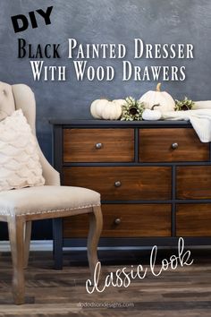 a black painted dresser with wood drawers and white pumpkins on the top, in front of a chalkboard wall