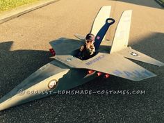 a young boy is sitting in a toy fighter jet