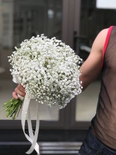 a person holding a bouquet of white flowers