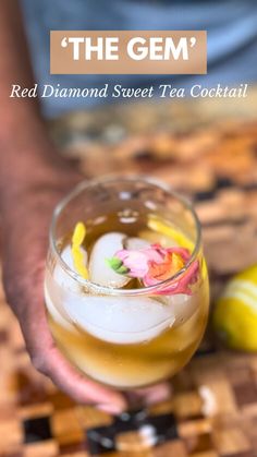 a person holding a drink in their hand with the text, the gem red diamond sweet tea cocktail