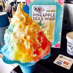 an ice cream sundae on a blue plate next to a box of pineapple dole whip